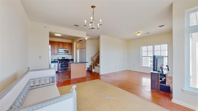 6910 Beach Front Rd, Arverne, NY 11692 - living room featuring light wood finished floors, a chandelier, and stairs