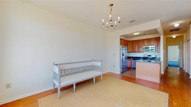 6910 Beach Front Rd, Arverne, NY 11692 - kitchen featuring stainless steel appliances, wood finished floors, a chandelier, and hanging light fixtures