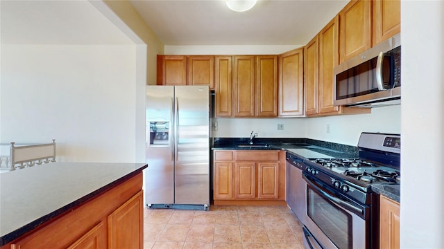 6910 Beach Front Rd, Arverne, NY 11692 - kitchen with appliances with stainless steel finishes, a sink, brown cabinets, and light tile patterned floors