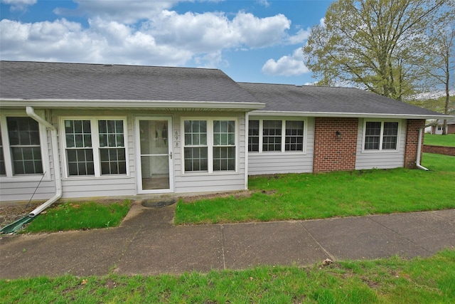 69 Enfield Ct Unit B, Ridge, NY 11961 - back of property featuring a lawn, roof with shingles, and brick siding