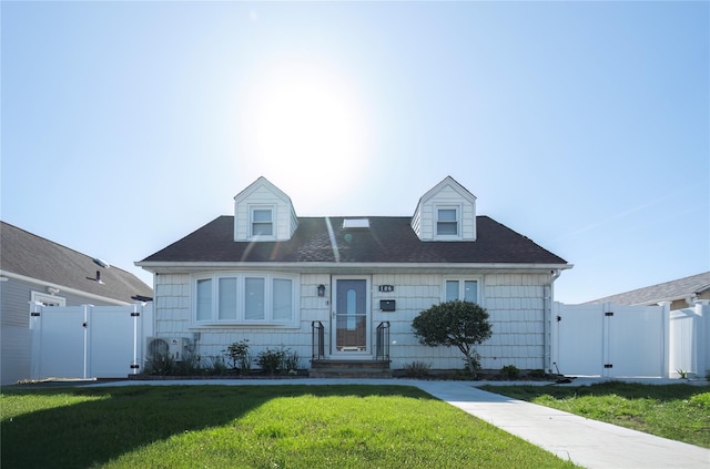 cape cod home featuring roof with shingles, a gate, fence, and a front yard