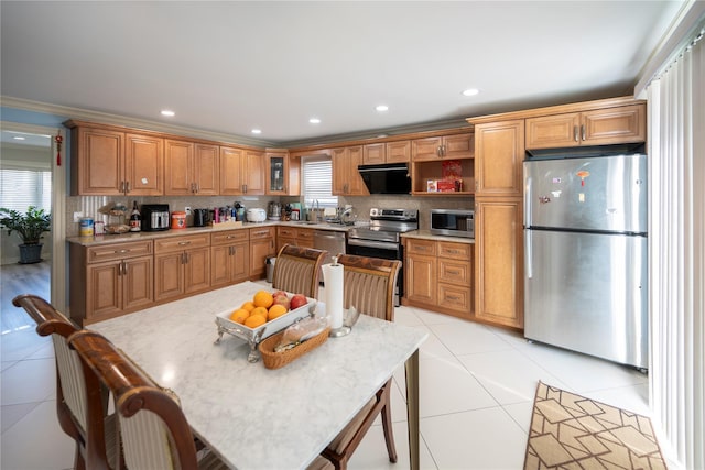 kitchen featuring decorative backsplash, light countertops, light tile patterned floors, and appliances with stainless steel finishes