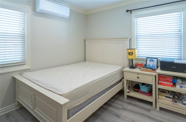 bedroom featuring a wall mounted air conditioner, light wood-style floors, multiple windows, and ornamental molding