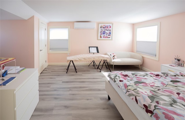 bedroom featuring a wall mounted AC and wood finished floors