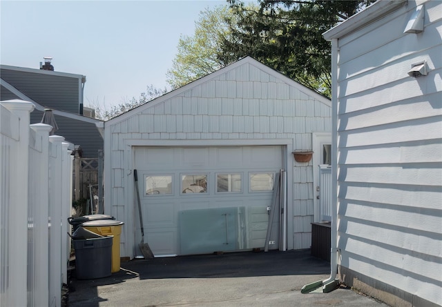detached garage with driveway and fence