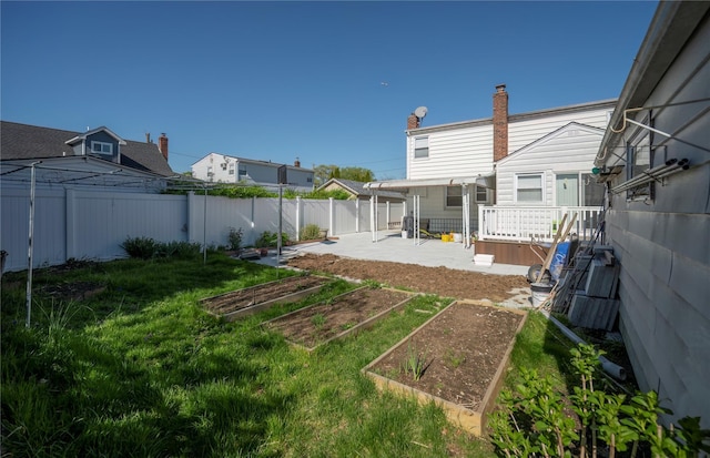 view of yard featuring a garden, a patio area, and a fenced backyard