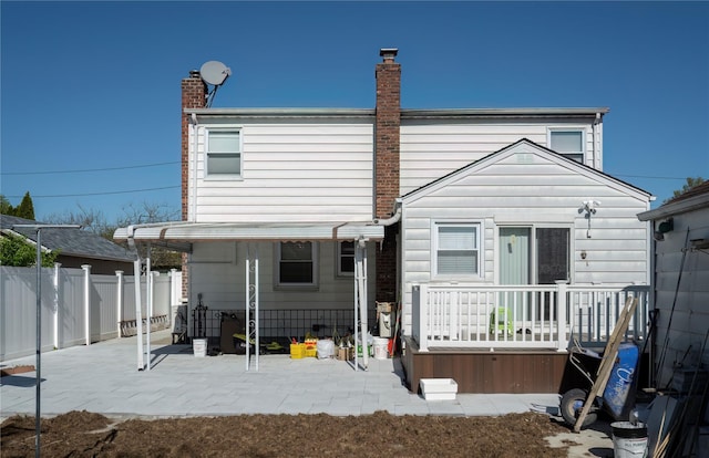 rear view of property featuring a fenced backyard, a patio area, and a chimney