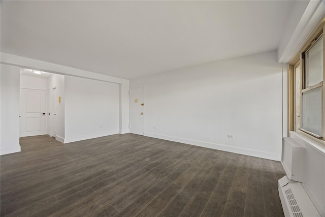 unfurnished living room with baseboards, dark wood-type flooring, and a baseboard heating unit