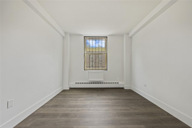 spare room featuring dark wood finished floors, baseboards, and baseboard heating