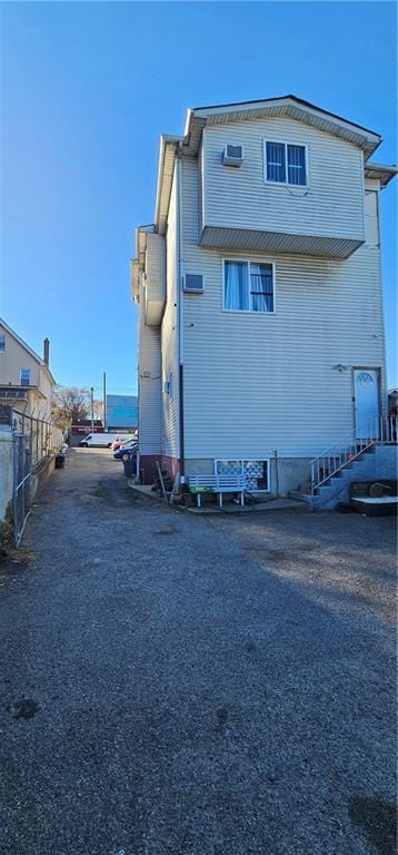 back of property featuring driveway and fence