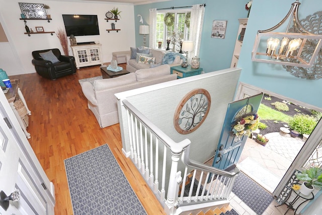 stairway featuring wood finished floors and a chandelier