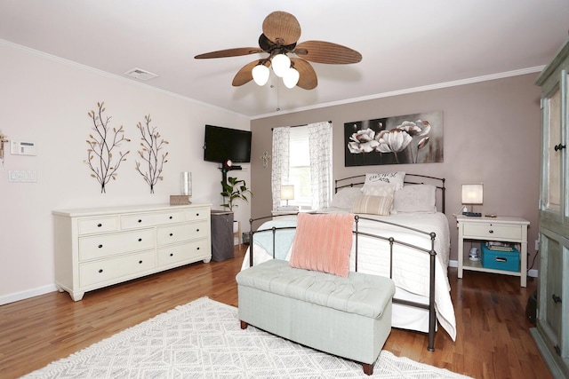 bedroom with ornamental molding, wood finished floors, ceiling fan, and baseboards