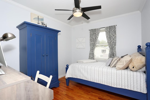 bedroom featuring ornamental molding, wood finished floors, ceiling fan, baseboards, and a closet