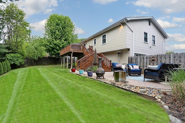 back of house featuring stairway, a patio, a deck, an attached garage, and an outdoor living space