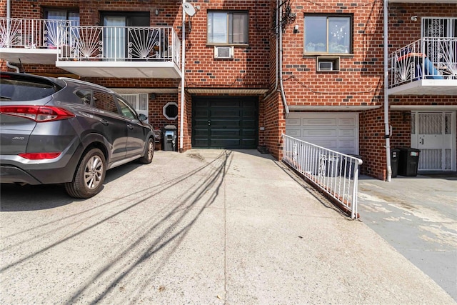 exterior space with an attached garage, driveway, and brick siding