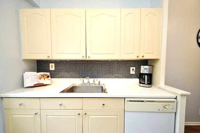 kitchen featuring dishwasher, a sink, tasteful backsplash, and light countertops
