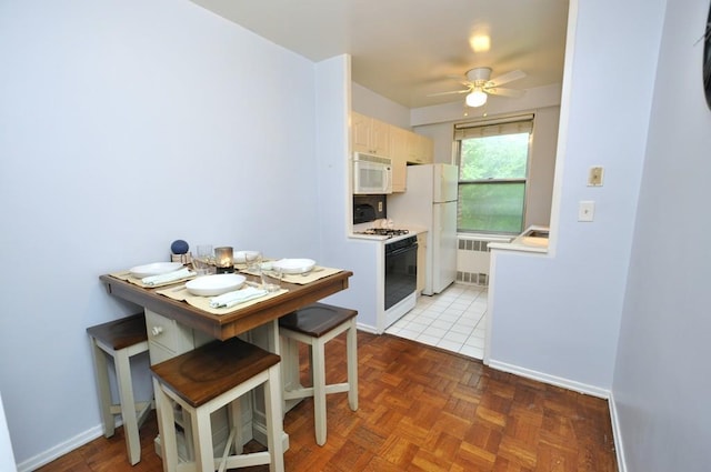 dining space featuring baseboards, a ceiling fan, and radiator