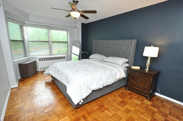 bedroom with radiator, baseboards, and a ceiling fan