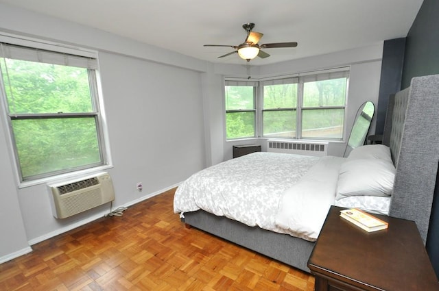 bedroom with multiple windows, radiator, a wall unit AC, and baseboards