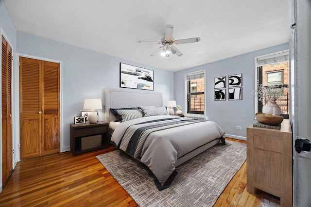 bedroom featuring light wood-type flooring, baseboards, and ceiling fan