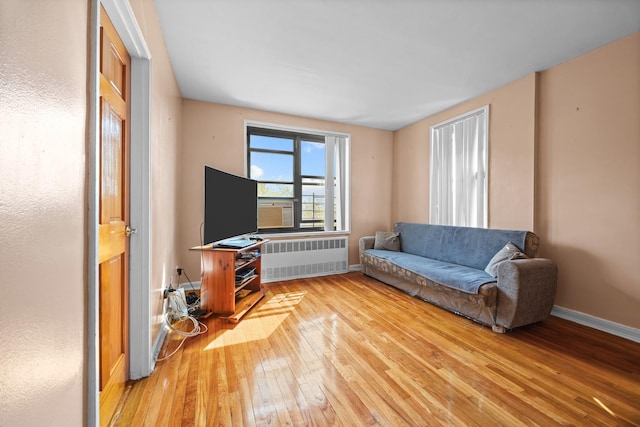 living area featuring radiator heating unit, wood-type flooring, and baseboards