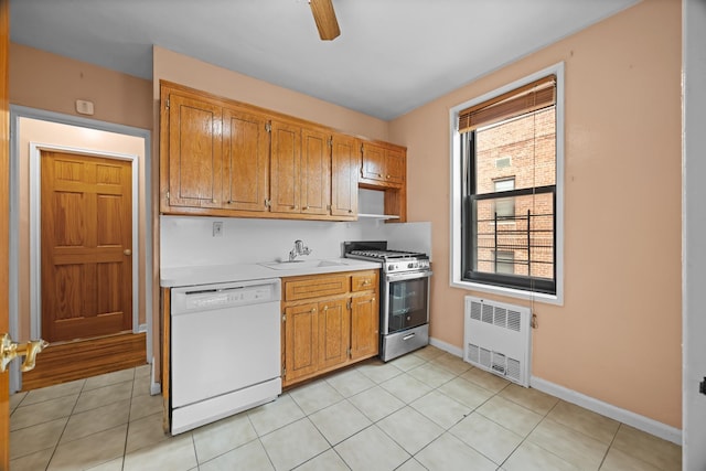kitchen with radiator, dishwasher, gas stove, a sink, and light countertops