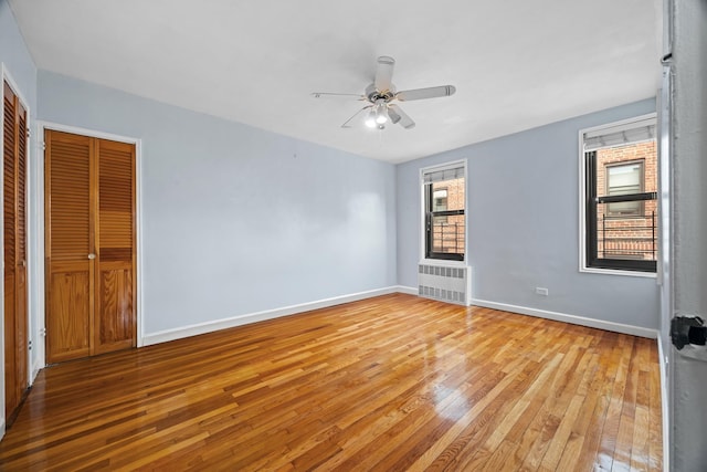 unfurnished bedroom with light wood-type flooring, baseboards, and a ceiling fan