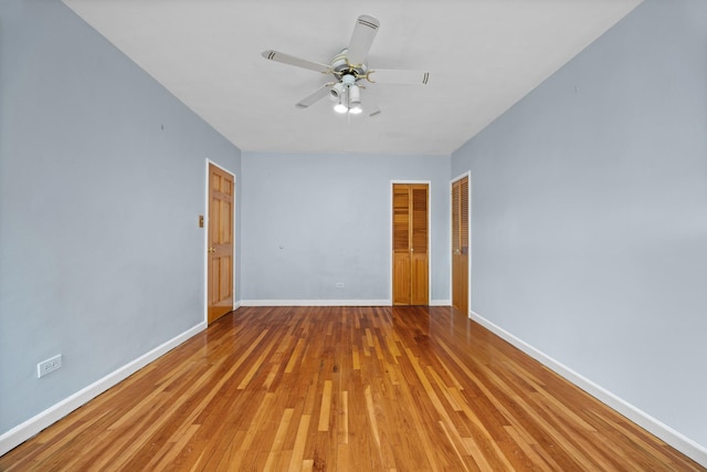 spare room featuring baseboards, light wood-style flooring, and ceiling fan