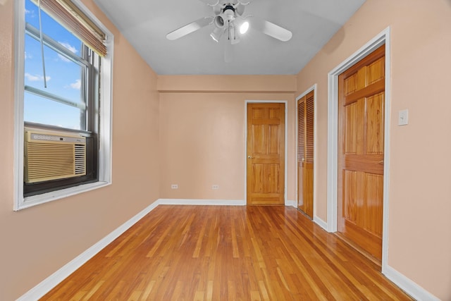 unfurnished bedroom with a closet, light wood-type flooring, baseboards, cooling unit, and ceiling fan