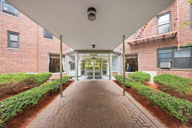view of exterior entry featuring brick siding and french doors