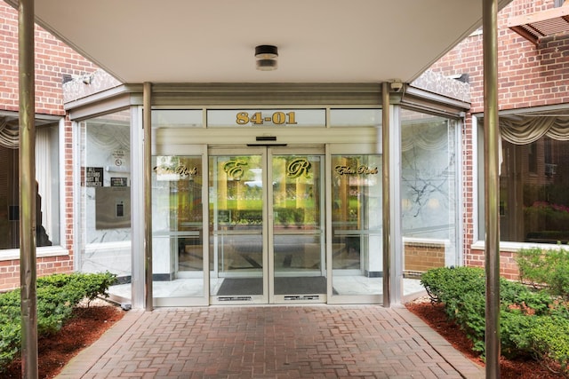 view of exterior entry featuring brick siding