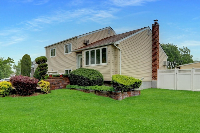 view of side of home featuring a yard, a chimney, and fence