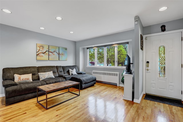 living room with baseboards, radiator heating unit, recessed lighting, and wood finished floors