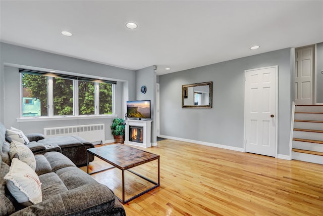 living area with light wood-style flooring, radiator, and plenty of natural light