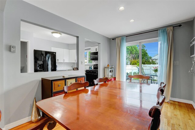 dining space featuring baseboards, light wood finished floors, and recessed lighting