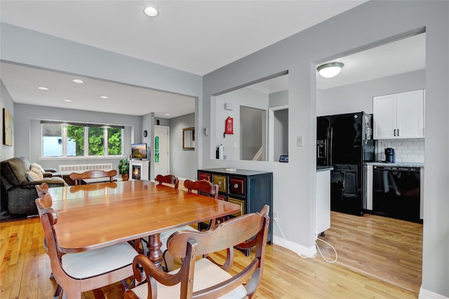dining room with radiator, recessed lighting, and light wood-type flooring