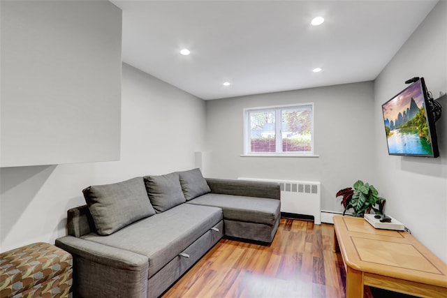 living room with radiator, light wood-style flooring, baseboard heating, and recessed lighting