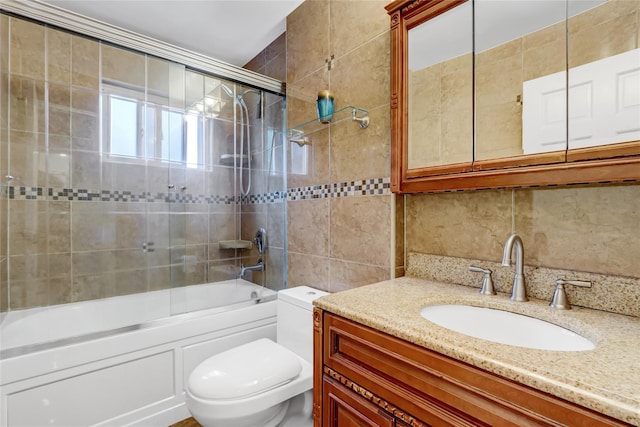 full bath featuring tile walls, toilet, bath / shower combo with glass door, vanity, and decorative backsplash