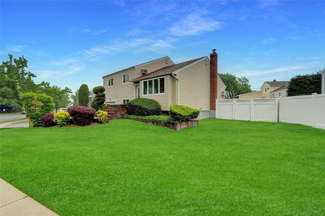 exterior space with fence, a front lawn, and a chimney