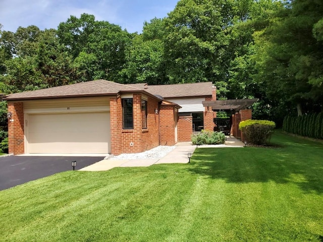 view of front of home with brick siding, asphalt driveway, a front lawn, and an attached garage