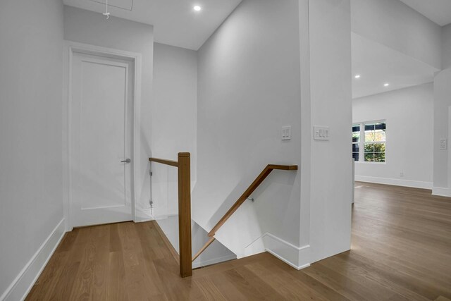 stairway featuring wood finished floors, attic access, baseboards, and recessed lighting