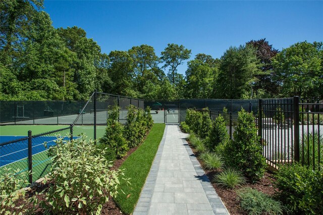surrounding community featuring a tennis court and fence