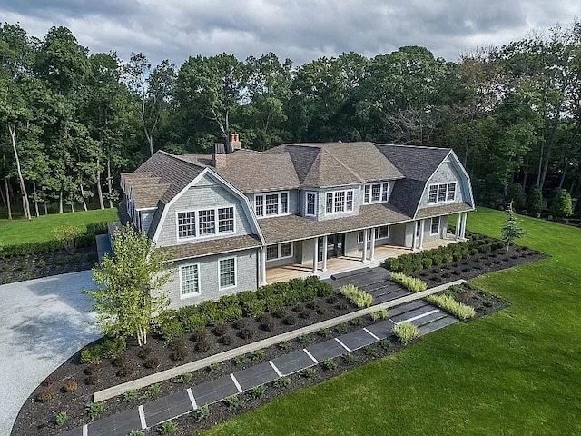 2 Short Path, Nissequogue, NY 11780 - view of front of house with a gambrel roof, a porch, a view of trees, and a front yard