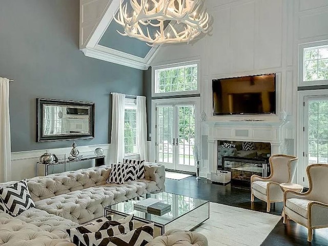 2 Short Path, Nissequogue, NY 11780 - living area featuring an inviting chandelier, plenty of natural light, a decorative wall, a towering ceiling, and ornamental molding