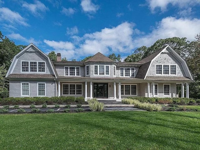 2 Short Path, Nissequogue, NY 11780 - view of front facade featuring a gambrel roof, a porch, a front lawn, and a chimney