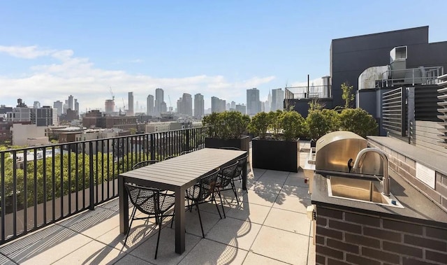 view of patio with area for grilling, outdoor dining area, a view of city, and a grill
