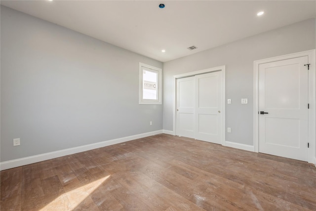unfurnished bedroom featuring a closet, visible vents, baseboards, light wood-style floors, and recessed lighting