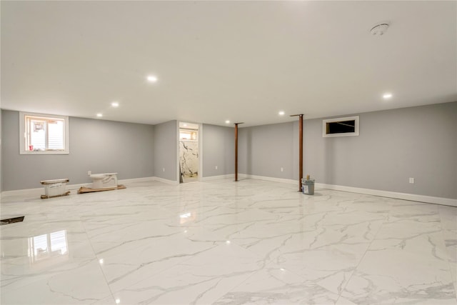 basement with marble finish floor, baseboards, and recessed lighting