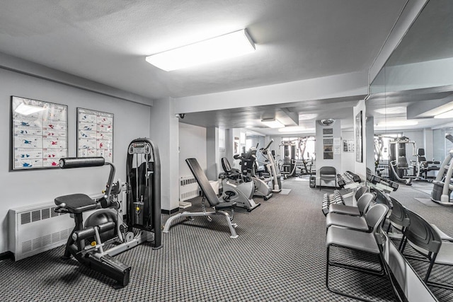 exercise room featuring baseboards and radiator