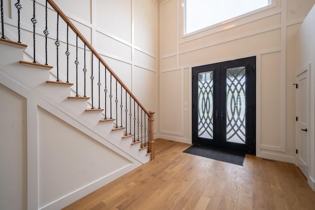 396 Argyle Rd, East Meadow, NY 11554 - entrance foyer with stairway, a decorative wall, a high ceiling, and wood finished floors